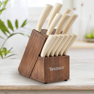 A set of knives with rice husk handles, displayed in a wooden block with the brand 'Tomodachi' inscribed on it, placed on a kitchen counter.