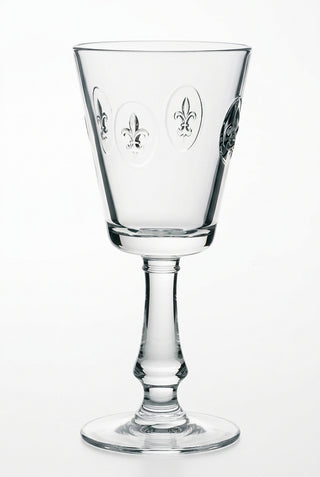 A clear glass wine glass with intricate detailing, featuring the Fleur de Lys symbol.